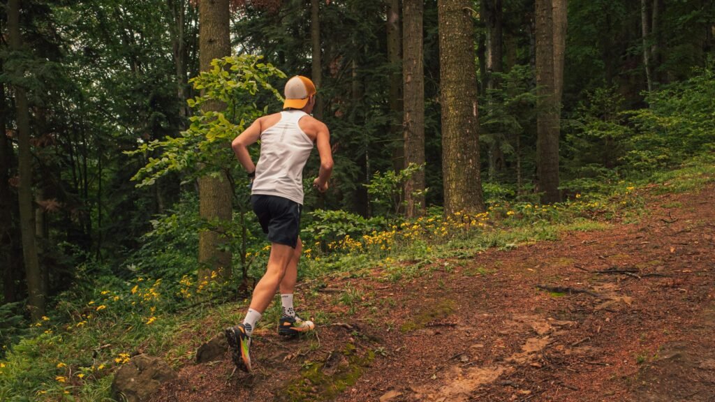 Traileur en pleine course de trail à La Réunion souffrant d'une douleur au genou en descente.