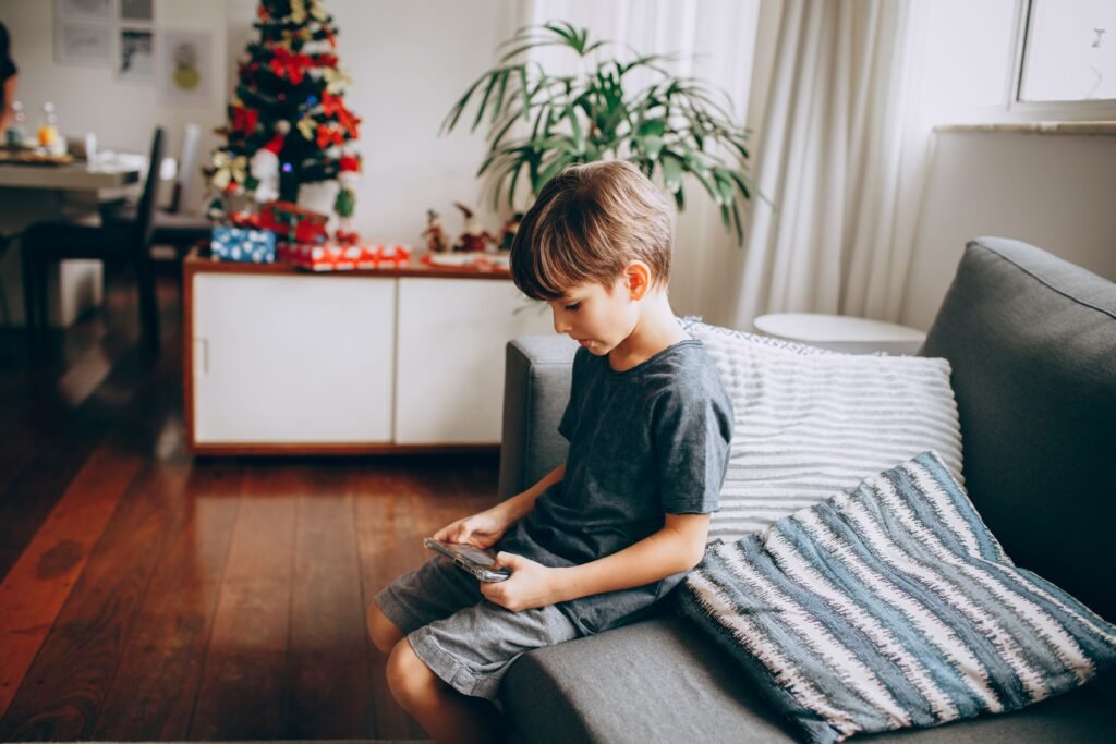 Posture inclinée d'un enfant jouant aux jeux vidéo : cause fréquente de tensions cervicales justifiant un check-up chiropratique.