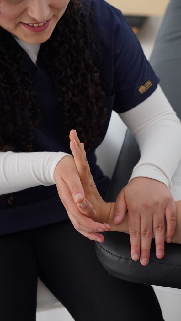 Prise en charge du canal carpien par Ophélie Rémont, chiropracteur à L'Étang-Salé, manipulant les os du poignet d'un patient.