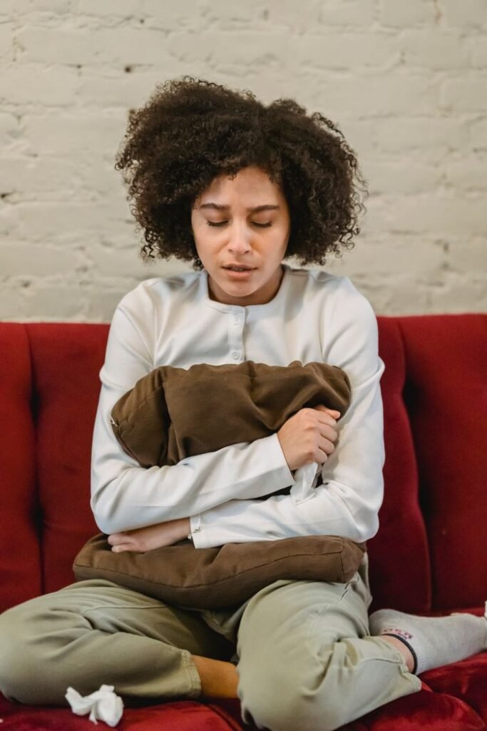 Jeune femme avec une bouillotte souffrant de règles douloureuses avant un bilan chiropratique