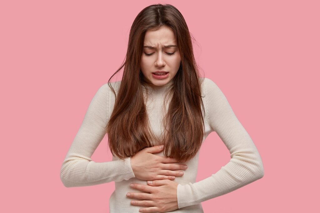 Règles douloureuses : une femme se tient le ventre, signe qu'un avis médical peut être utile